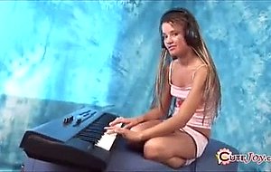 Cute teeny in large headphones playing a synthesizer, getting naked ...