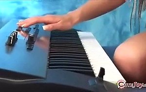 Cute teeny in large headphones playing a synthesizer, getting naked ...