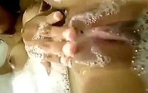 A horny big-tittied chick plays with herself inside the tub
