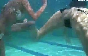 Two girls swims underwater