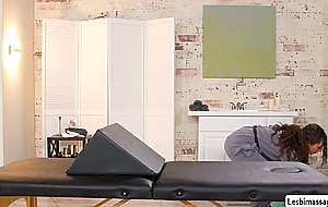 Curly haired masseuse gives a finger massage with a bolster