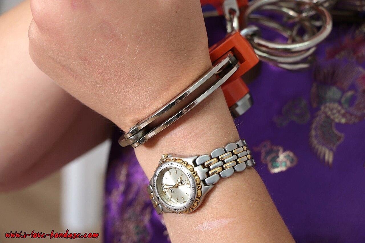 Short haired girl with piercings is restrained with cuffs wearing a kimono